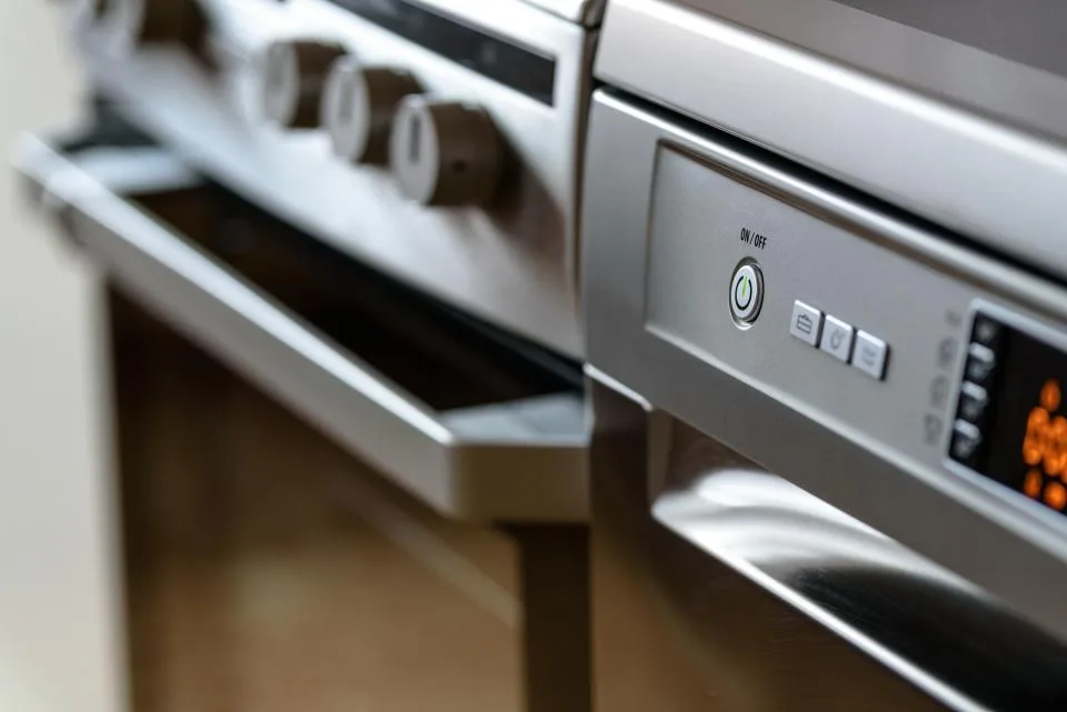 Close-up of the stainless steel knobs and buttons on a kitchen oven