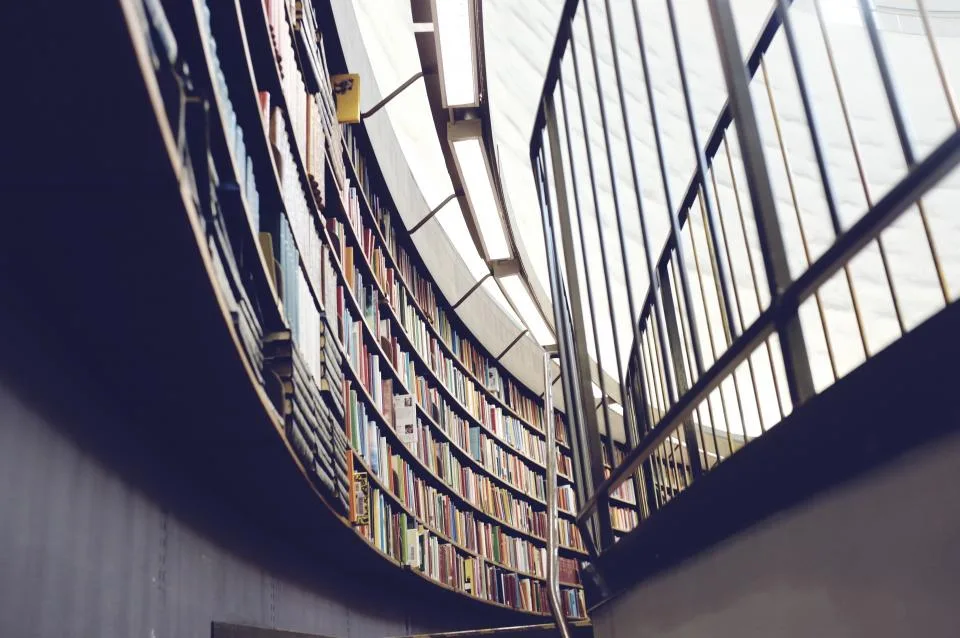 Curved rows of bookshelves in a multi-level library seen from below