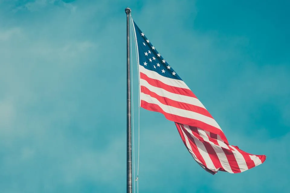 An American flag flying against a blue sky