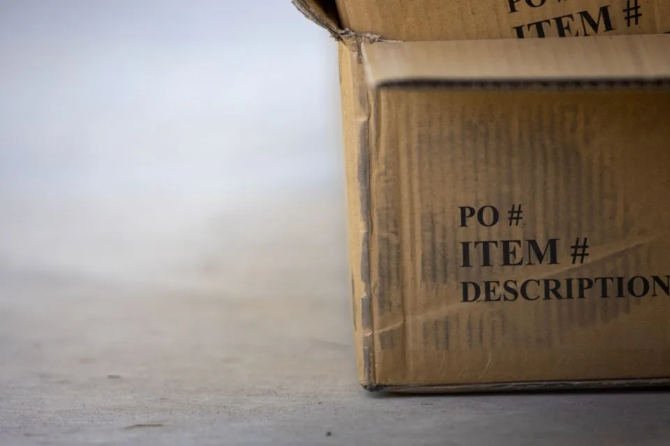 A cardboard shipping box sitting on a concrete floor