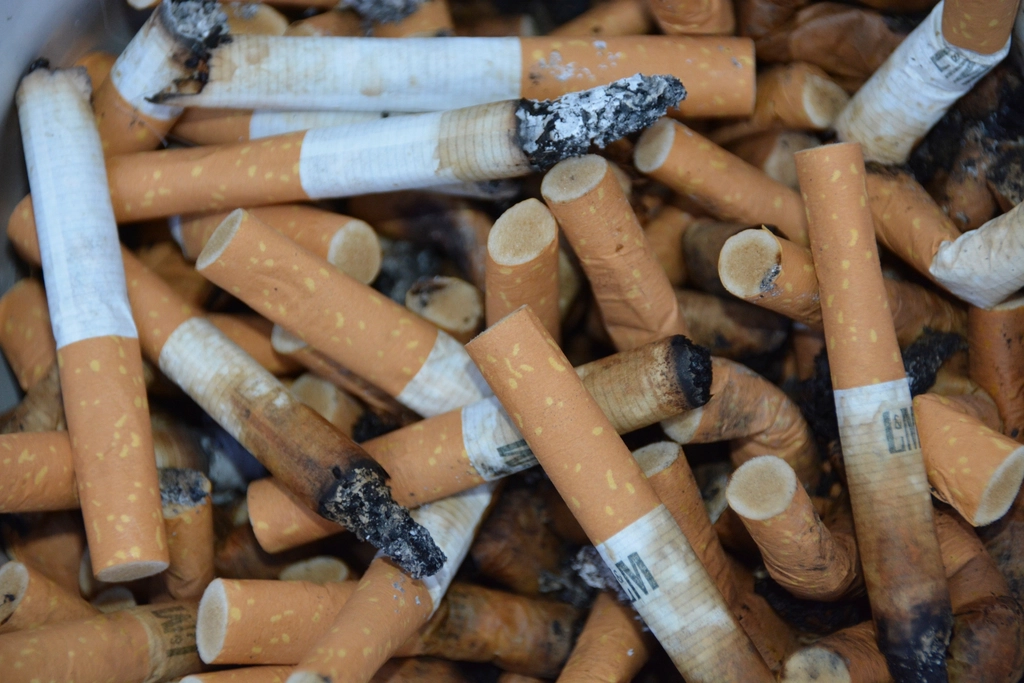 A pile of stubbed-out cigarette butts in an ashtray