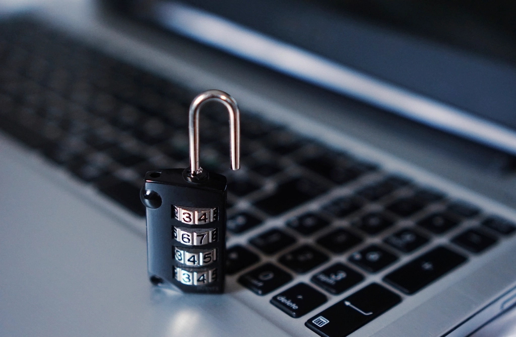 A small combination padlock resting on a laptop keyboard