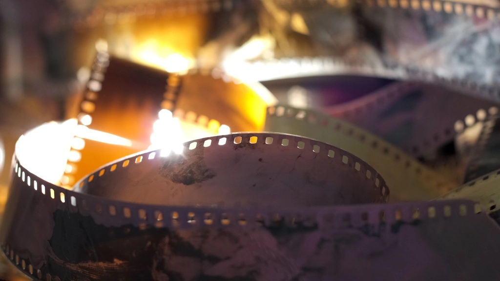 Close-up of curled strips of old movie film lit from behind