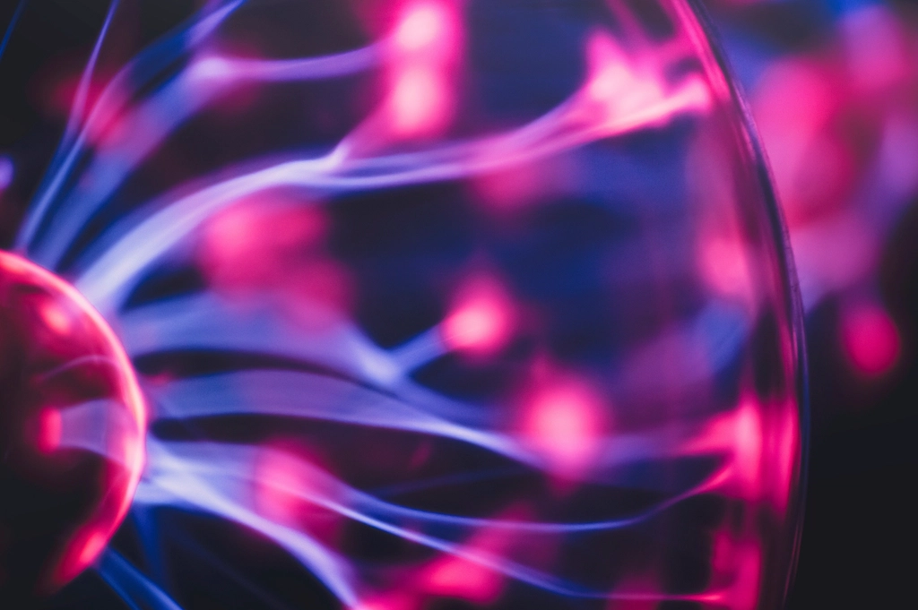 Close-up of glowing pink and blue plasma filaments