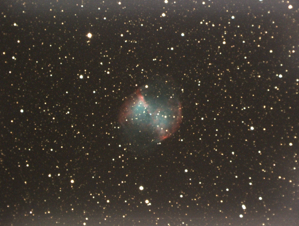 A glowing planetary nebula, the cast-off gas of a dying star, against a field of stars