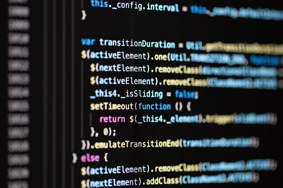 Close-up of colorful programming code on a dark computer screen, with shallow focus